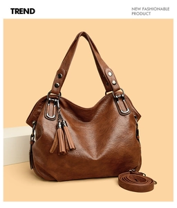 Detail of vintage brown tote bag with decorative tassels and textured faux leather finish