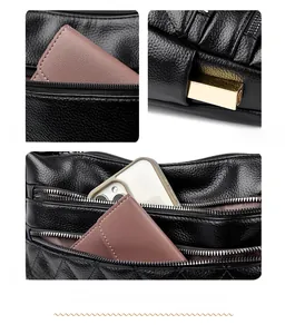 Detail view of black lychee leather crossbody bag with multiple zipper compartments and pockets