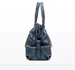Detail view of dark blue tote bag showing pebbled leather texture and metal hardware