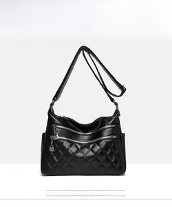 Front view of black quilted crossbody bag with double zippers and silver charms