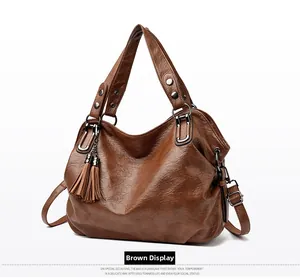 Close-up of brown vintage texture tote bag with stylish tassel and dual handles