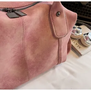 Close-up of dusty pink tote bag showing soft matte texture and dual zipper detail