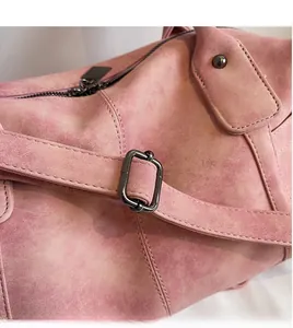 Close-up of the adjustable shoulder strap and metal zipper on the vintage tote bag