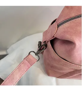 Detailed close-up of durable metal hooks and suede texture on pink tote bag straps