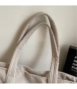 Detail showing high-quality corduroy texture and sturdy shoulder strap of gray tote bag