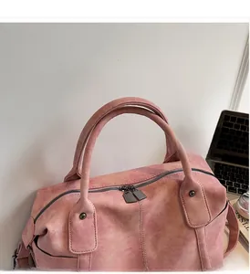Close-up of pink Boston bag with durable round handles and vintage metal zippers