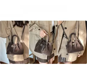 Three-way view of textured leather bucket bag with contrast stitching and adjustable strap