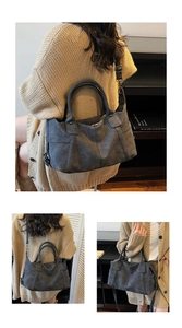 Detail view of large dark grey frosted tote bag with cylindrical handles and adjustable strap