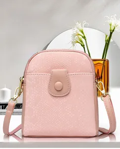 Close-up of pink faux snake skin texture on a small crossbody bag with gold accents