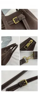 Detailed close-up of brown lychee leather bucket bag with contrast white stitching and gold hardware