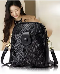 Close-up of black snakeskin patterned PU crossbody bag with golden magnetic clasp