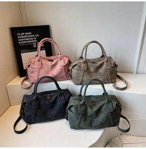 Detailed view of vintage matte Boston handbags in four colors on a tiered display stand