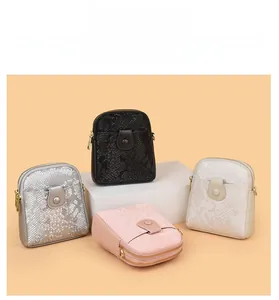 Detail of four mini crossbody bags with snake skin texture and gold double zipper pockets