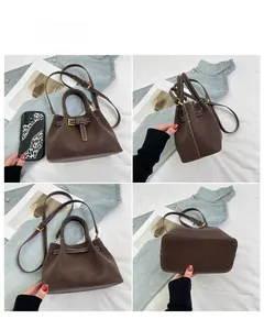 Detail view showing textured brown bucket bag with contrast stitching and golden hardware
