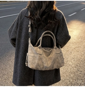 Macro shot of grey vintage textured tote bag with detachable strap in warm sunset light