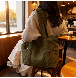 Detail of vintage olive green corduroy tote bag showing side zipper pocket and texture