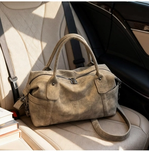 Detail of a vintage Boston travel bag in sage green with metal lock and textured leather