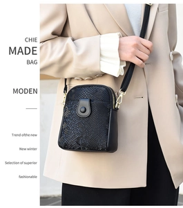 Detail of minimalist black snake pattern crossbody bag with gold metallic hardware
