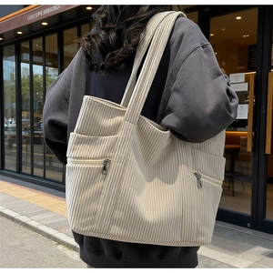 Detail of beige corduroy tote bag showing side pocket and large capacity for commuting