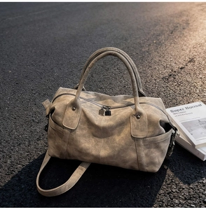 Close-up of vintage taupe tote bag with matte leather texture and silver double zippers