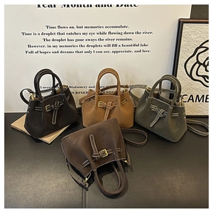 Detail view of four leather bucket bags in various colors with contrast stitching and metal buckles