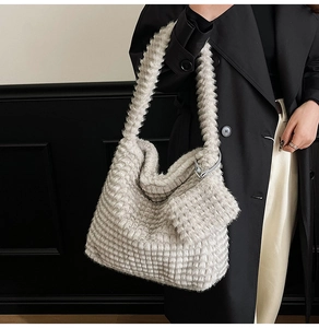 Close-up of cream fuzzy tote bag with textured plush fabric and matching mini pouch