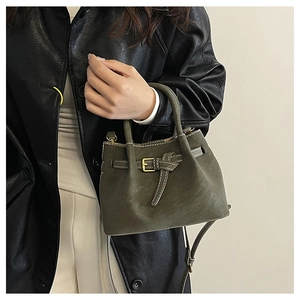 Detail of retro olive green bucket bag with belt buckle and vintage matte leather texture