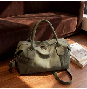 Detailed close-up of an olive green matte tote bag with dual handles on wooden floor
