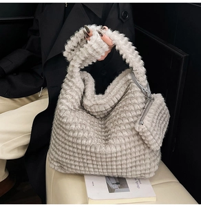 Close-up of light gray plush cloud tote bag with ribbed texture and small zipper pouch