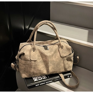 Close-up of vintage brown tote bag with matte texture, dual handles and adjustable strap