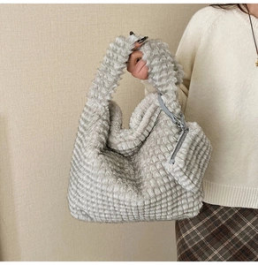 Detail of grey plush cloud bag with textured faux fur and matching mini zipper pouch
