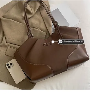 Detail of a brown tote bag showing cross-hatch PU leather texture and contrast stitching