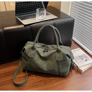 Detail view of a vintage dark green Boston bag with double zippers and long strap