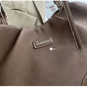 Detailed close-up of premium canvas texture and leather patch with white stitching on tote bag