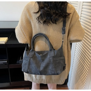 Detail of dark grey tote bag featuring adjustable strap and premium matte texture leather
