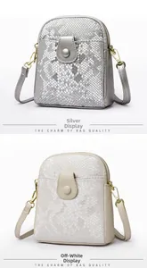Close-up of small crossbody bags with snake texture in silver and beige finishes