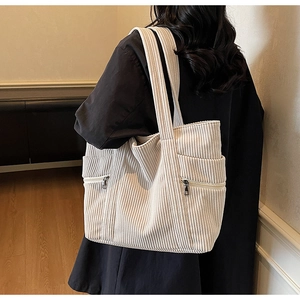 Detail view of the large capacity beige corduroy tote bag with side zipper pockets
