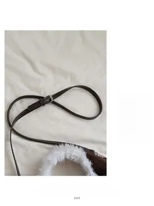 Détail du sac seau marron foncé avec bandoulière en cuir réglable et bordure en fausse fourrure