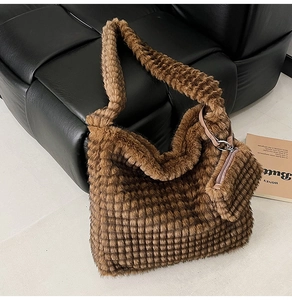 Detail of dark brown plush tote bag with grid quilting and small matching zipper pouch