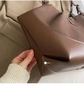 Detail shot of vintage tote bag showing premium leather stitching and contrast white thread