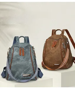 Detail of grey-blue and brown soft canvas backpacks with woven straps and metal accents