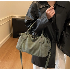 Detailed view of dark green retro Boston bag with functional side pockets and suede texture