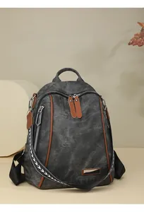 Close-up of vintage grey canvas backpack with brown leather trim and woven strap details