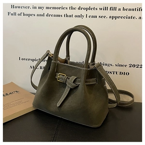 Detail of the vintage dark grey-green bucket bag featuring metal buckle and textured material