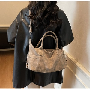 Detail of vintage grey tote bag showing textured synthetic leather and detachable strap