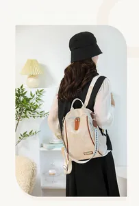 Close-up of stylish beige soft leather backpack with brown zipper details and side strap