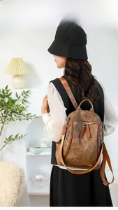 Close-up of vintage brown leather backpack featuring durable zippers and woven straps