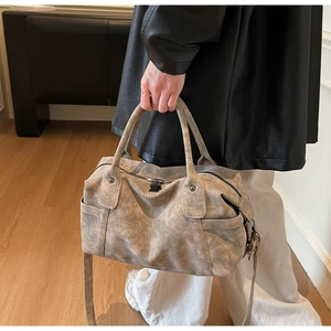 Detail of vintage grey boston bag with matte leather texture and elegant handles
