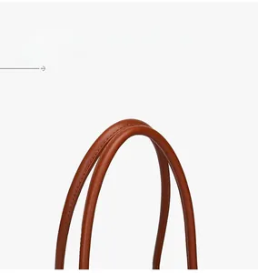 Detailed close-up of durable brown leather tote handle with refined stitching craftsmanship
