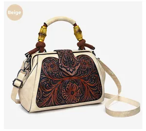 Detail of retro floral embossed beige handbag with bamboo handle and braided knot
